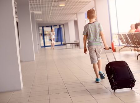 Little child - boy carrying his luggage at airportの写真素材