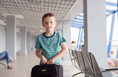 Little child - boy carrying his luggage at airportの写真素材