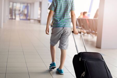 Little child - boy carrying his luggage at airportの写真素材