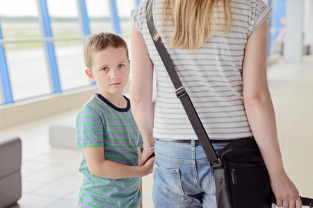 Sad child, boy travelling with his motherの写真素材
