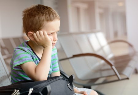 Bored child boy waiting at the airport - canceled flightの写真素材