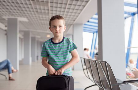 Little child - boy carrying his luggage at airportの写真素材