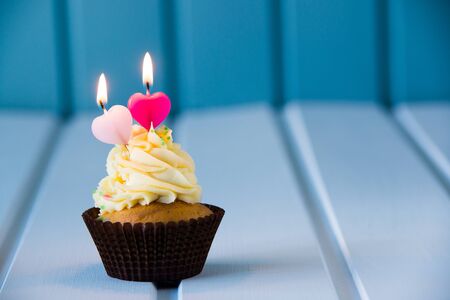 Birthday's cake - cupcake with a heart shaped candles for 2 - second birthday or valentine's day.の写真素材
