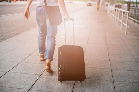 Woman passes through the airport terminal with her luggageの写真素材
