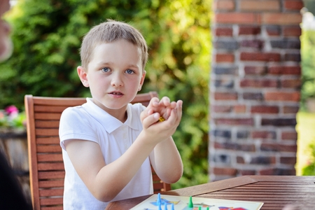 Little boy playing ludo board game on the terraceの写真素材