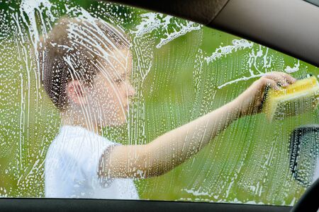 Little boy washing car in the garden. Summerの写真素材