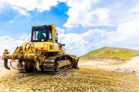 Yellow bulldozer on tracks at the mountain road constructionの写真素材