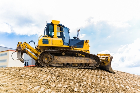 Yellow bulldozer on tracks at the mountain road constructionの写真素材