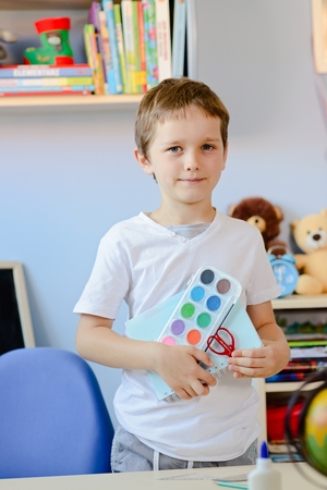 7 years old boy holding school accesories in his hand. Back to schoolの写真素材