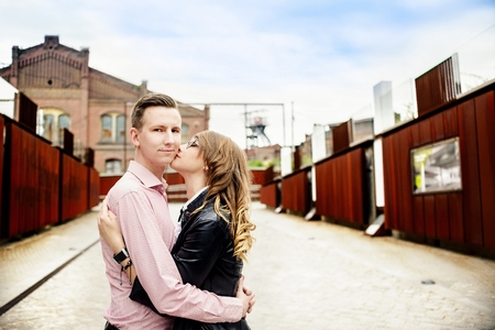 Young couple kissing and hugging outdoor. Engagement session. Girl wears glassesの写真素材