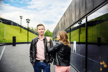 Young couple in love dating. Engagement session. Dressed in black leather jackets. Girl wears glassesの写真素材