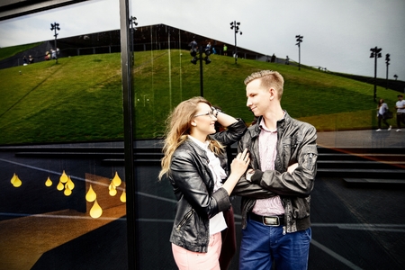 Young couple in love dating. Engagement session. Dressed in black leather jackets. Girl wears glassesの写真素材