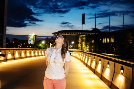 Young girl in glasses looking up at nightの写真素材