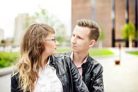 Young couple in love dating. Engagement session. Dressed in black leather jackets. Girl wears glassesの写真素材