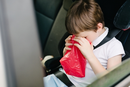 Seven years old child vomiting in car - suffers from motion sicknessの写真素材