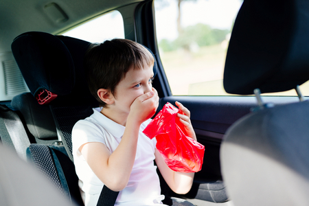 Seven years old child vomiting in car - suffers from motion sicknessの写真素材