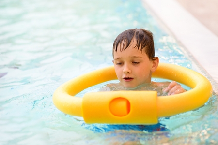 Seven years old boy learning to swim at the pool. Swimming schoolの写真素材