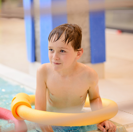 Seven years old boy learning to swim at the pool. Swimming schoolの写真素材