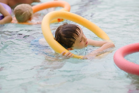 Seven years old boy learning to swim at the pool. Swimming schoolの写真素材