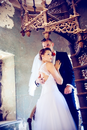 Newlyweds hugging near old stairs . Wedding day. Wedding sessionの写真素材