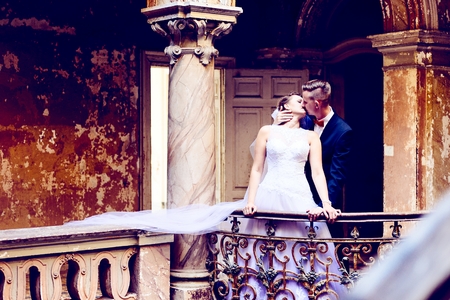 Bride and groom kissing on the balcony in the old palace. Wedding day. Wedding sessionの写真素材