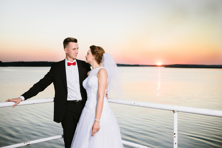 Bride and groom on the pier at sunset. Wedding day. Wedding sessionの写真素材
