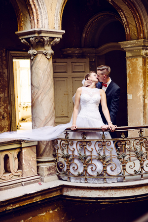 Bride and groom kissing on the balcony in the old palace. Wedding day. Wedding sessionの写真素材