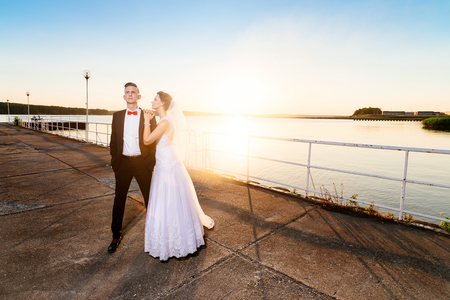 Bride and groom on the pier at sunset. Wedding day. Wedding sessionの写真素材