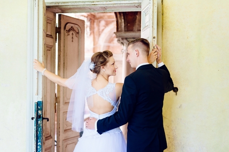 Young beautiful bride and groom near old door . Wedding day. Wedding sessionの写真素材