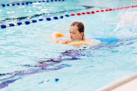 Seven years old boy learning to swim at the pool. Swimming schoolの写真素材