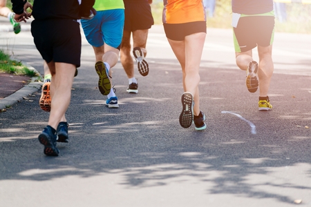 Marathon running street race, people feet on city roadの写真素材