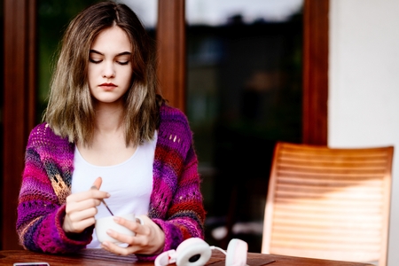 Young woman relaxing on terrace with cup of coffeeの写真素材