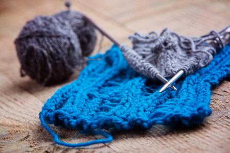 Knitting needles and wool on old wooden background. Wool knittingの写真素材