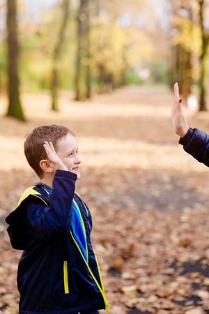 Mother giving a hi-five her little son in the parkの写真素材