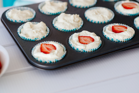 Delicious sweet cupcakes with strawberry in baking trayの写真素材