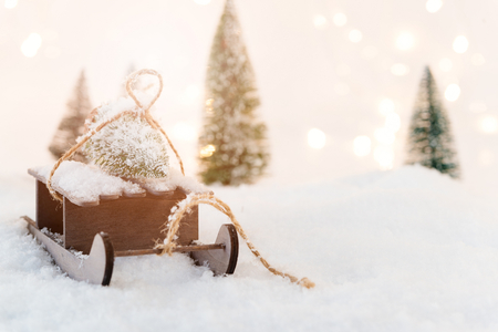 Small wooden sleigh with a Christmas tree in the snow. Christmas backgroundの写真素材