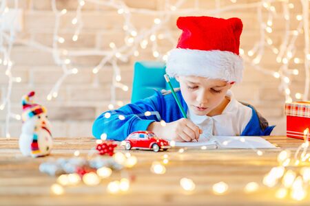 Small baby boy writes a list of gifts for Christmasの写真素材