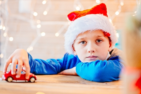 Little child boy playing with small red toy car - a Christmas presentの写真素材