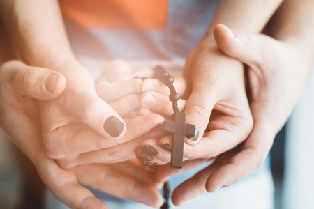 Family praying together. Holding rosary in hand. More from this series in my portfolioの写真素材