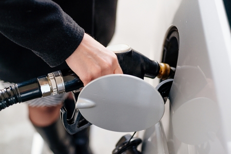Woman refueling car with diesel at the gas stationの写真素材