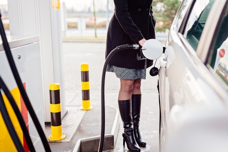 Woman refueling car with diesel at the gas stationの写真素材