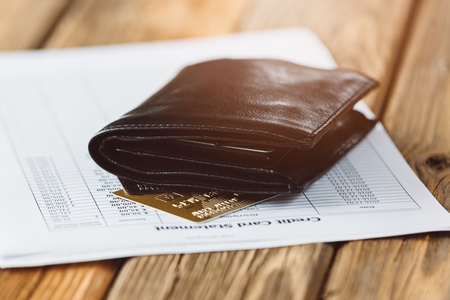 Credit card account statement with two cards and black leather wallet