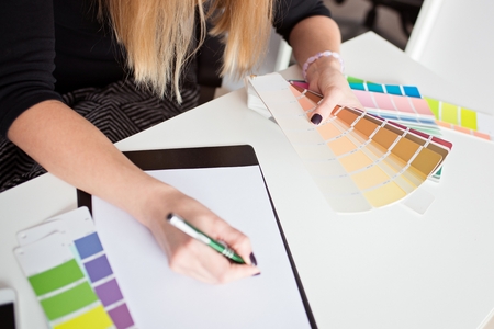 Woman designer or architect choosing color from color palette