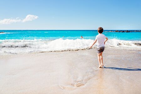 Happy 7 years boy child playing on the beach. Tenerife, Playa del Duque, Costa Adeje,の写真素材