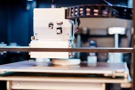 Working 3d printer printing white plastic prototype