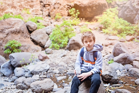 Little boy child drinking bottled mineral water on mountain trail. Mountain adventure. Masca Valley, Tenerife island, Canary Islands, Spainの写真素材