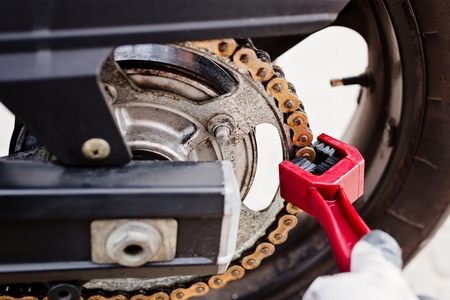 Cleaning motorcycle chain with dedicated chain brushの写真素材