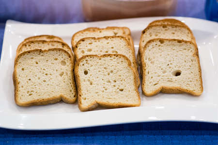 Fresh crunchy bread slices on white plate