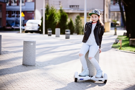 10 years old girl riding on self balancing electric skateboard - an electrical scooterの写真素材