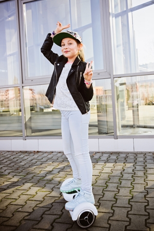 10 years old girl riding on self balancing electric skateboard - an electrical scooter